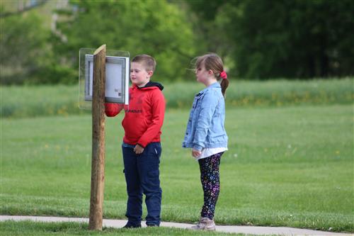 Two students look at a page in a book.