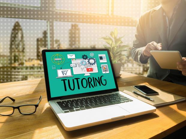 computer sitting on a desk with the word tutoring on its display